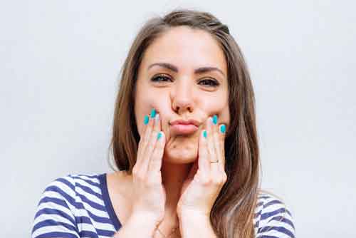 squeezing her cheeks