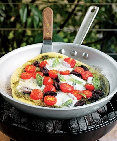 barbecue pizza topped with pesto tomatoes mozzarella and olives