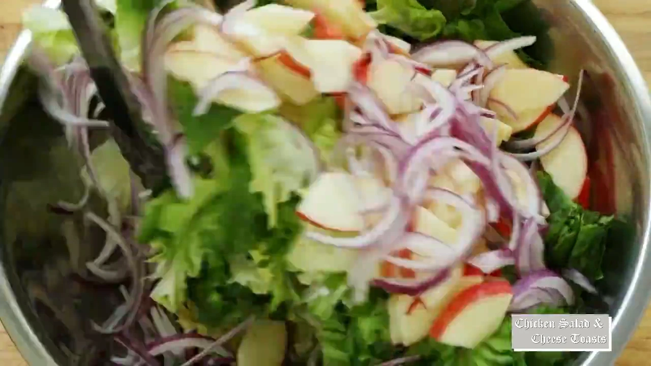 Escarole apples and red onion being tossed together