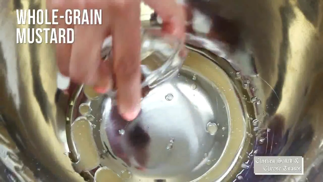 Mustard dressing being whisked in a metal bowl