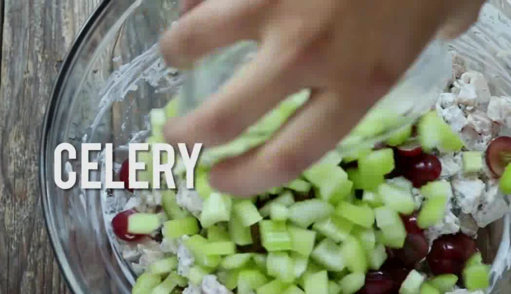 Adding grapes and celery to chicken salad filling.