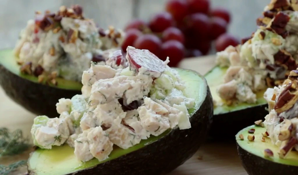 Filling avocado halves with chicken salad.