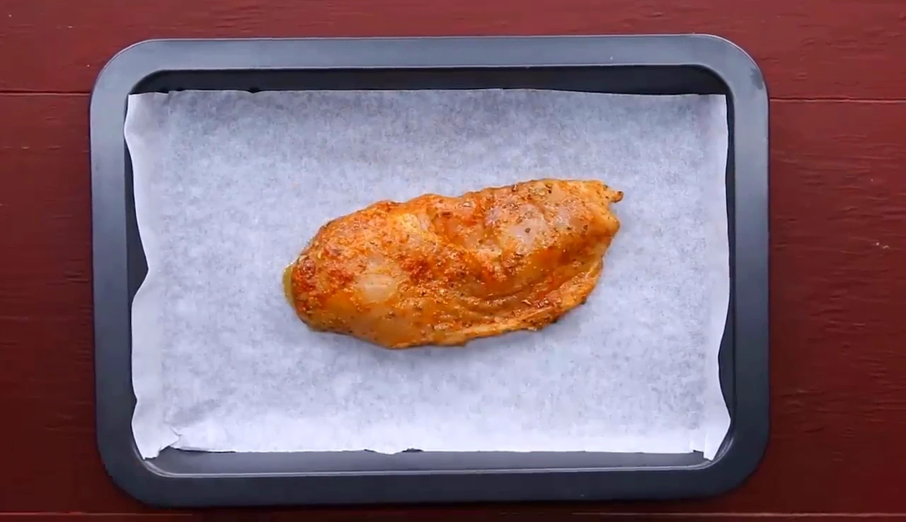 Chicken breast on a lined tray ready to bake