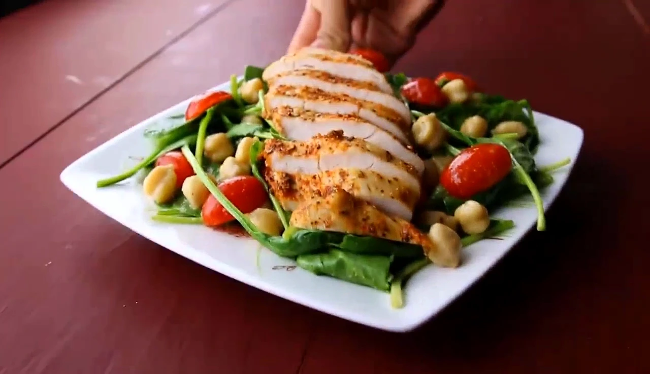 Finished chickpea spinach salad topped with sliced chicken