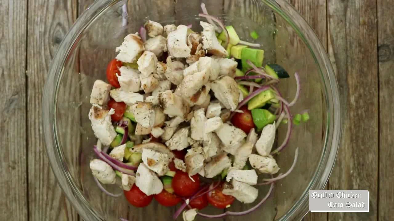 Adding chopped grilled chicken to taco salad.