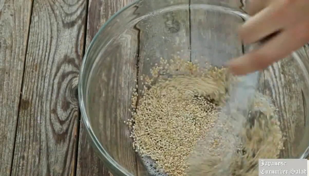 Adding sesame seeds to the dressing for Japanese cucumber salad.