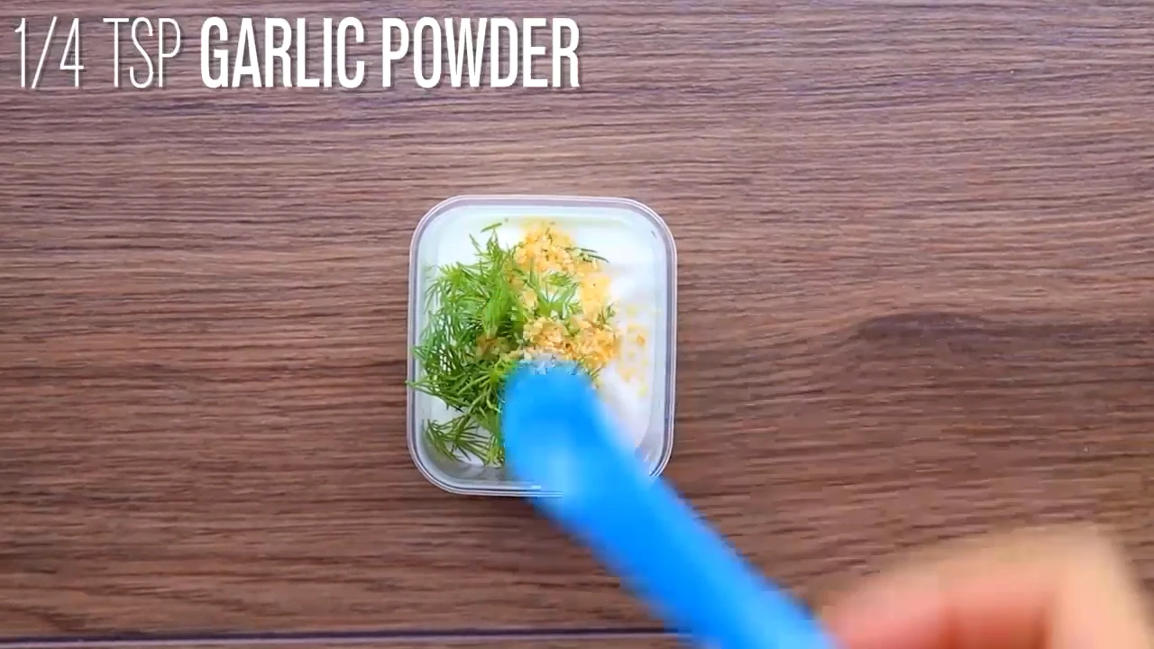 Dill yogurt dressing being stirred in a small container