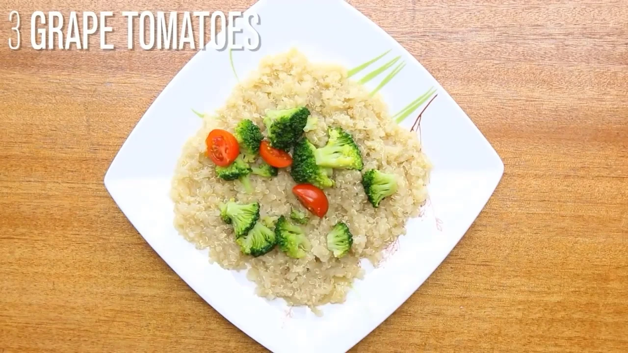 Plated quinoa topped with broccoli and tomatoes.