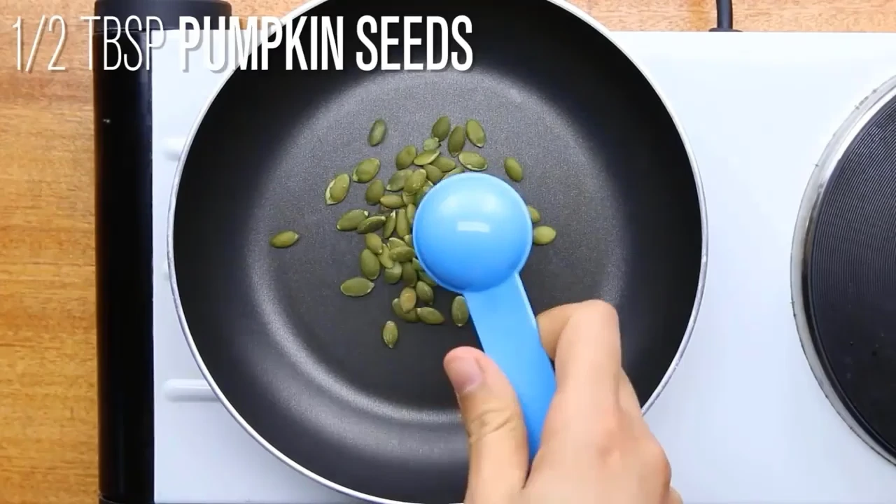 Toasting pumpkin seeds in a pan.