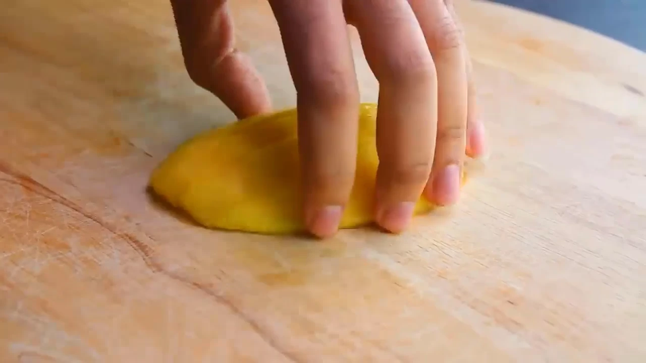 Cutting mango for quinoa fruit salad.
