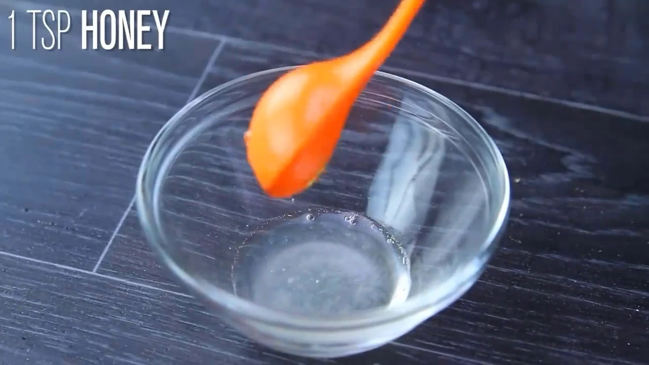 Drizzling honey into quinoa fruit salad.