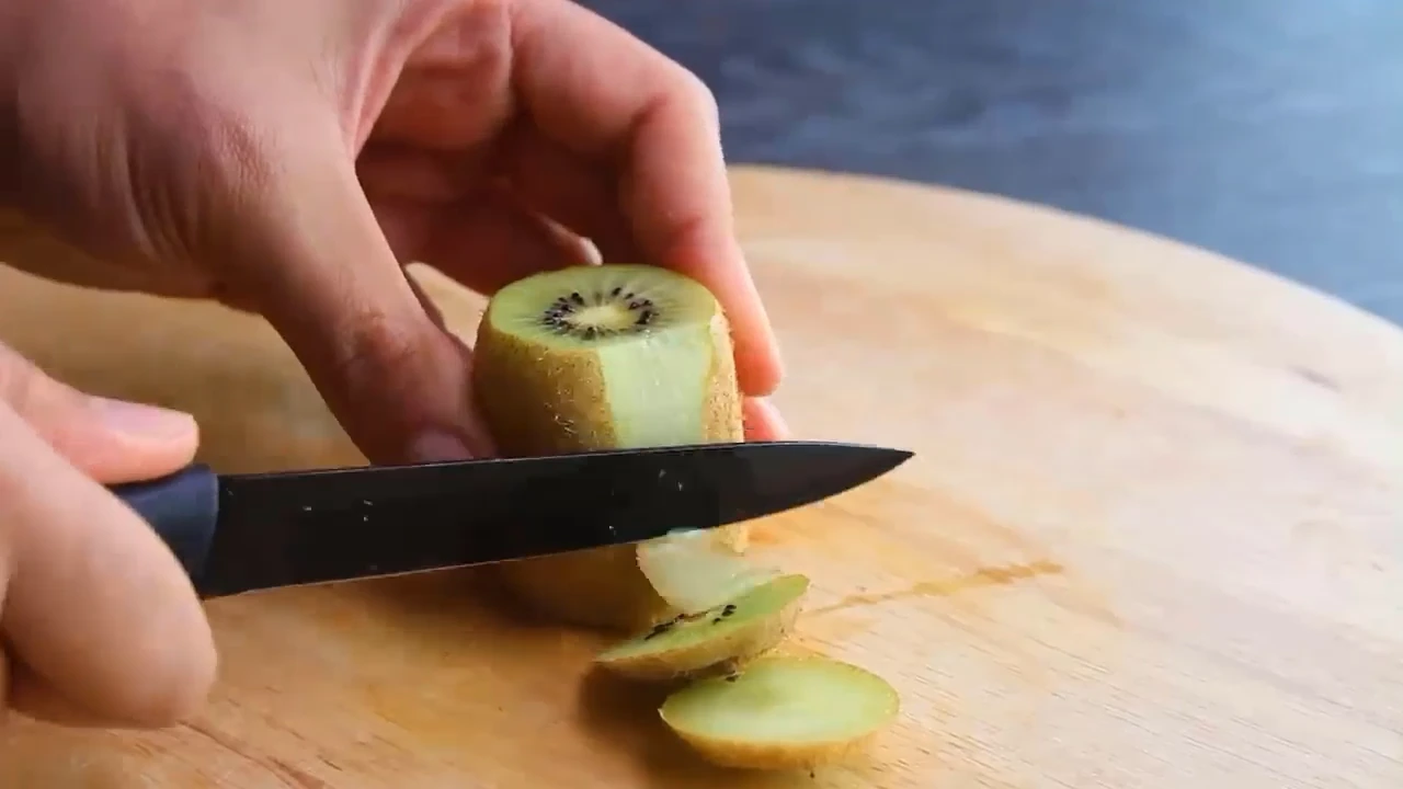 Slicing kiwi for quinoa fruit salad.
