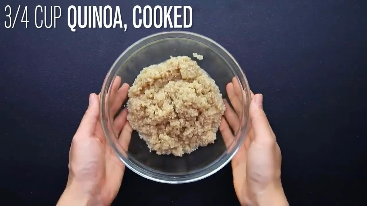 Adding cooked quinoa to the bowl for quinoa salad.
