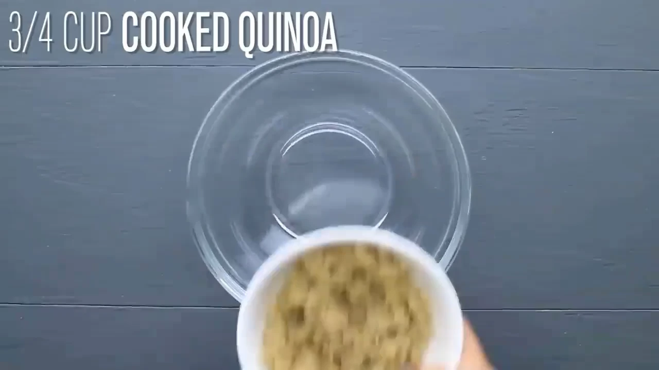 Adding cooked quinoa to the bowl for quinoa salad with feta.