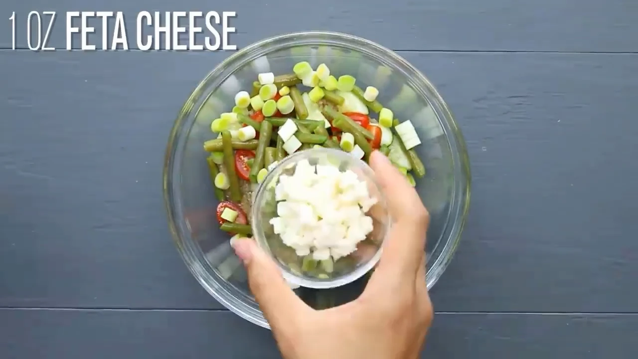 Adding feta to quinoa salad with feta.