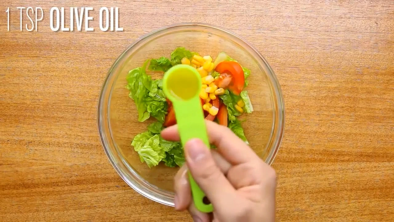 Finishing roasted chicken salad with lemon juice and olive oil.