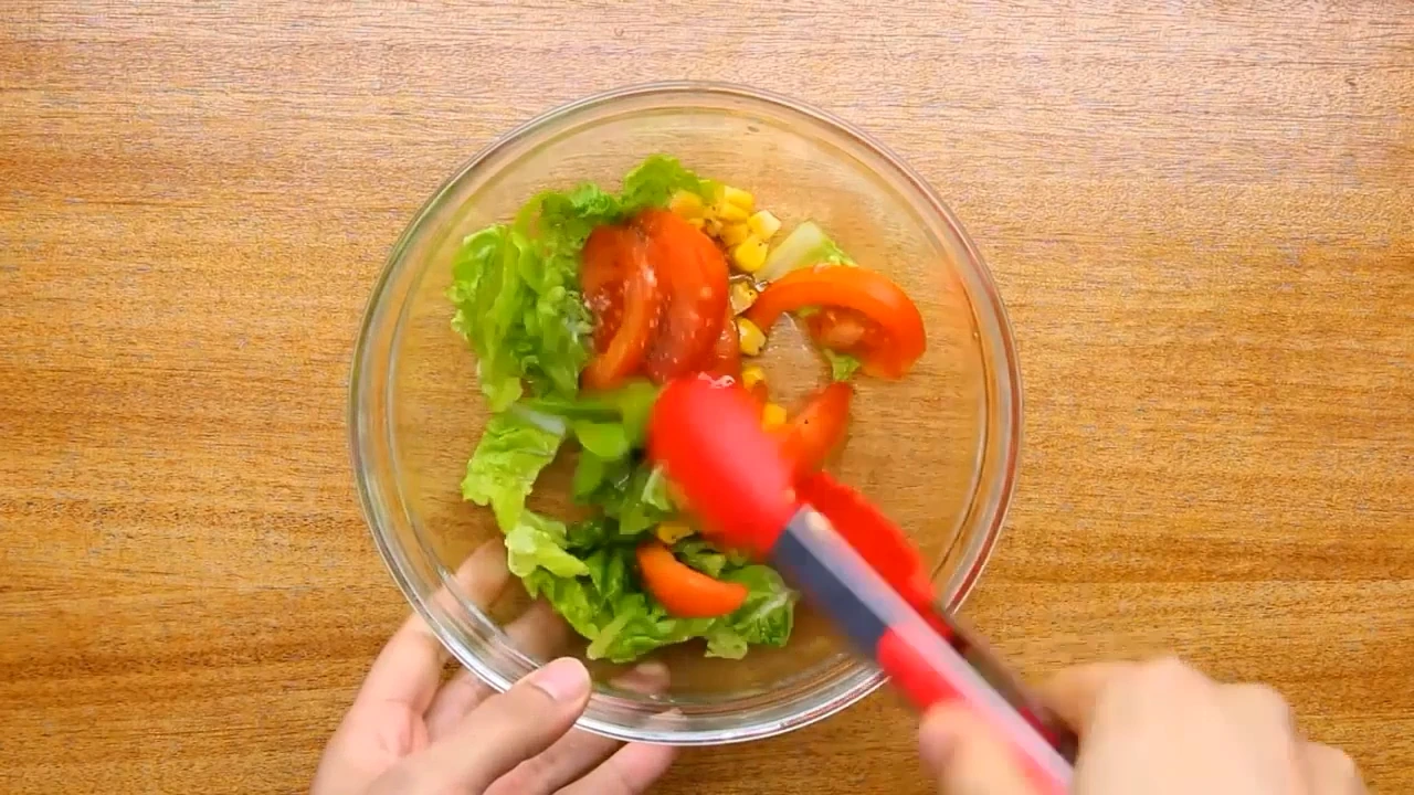 Tossing roasted chicken salad.