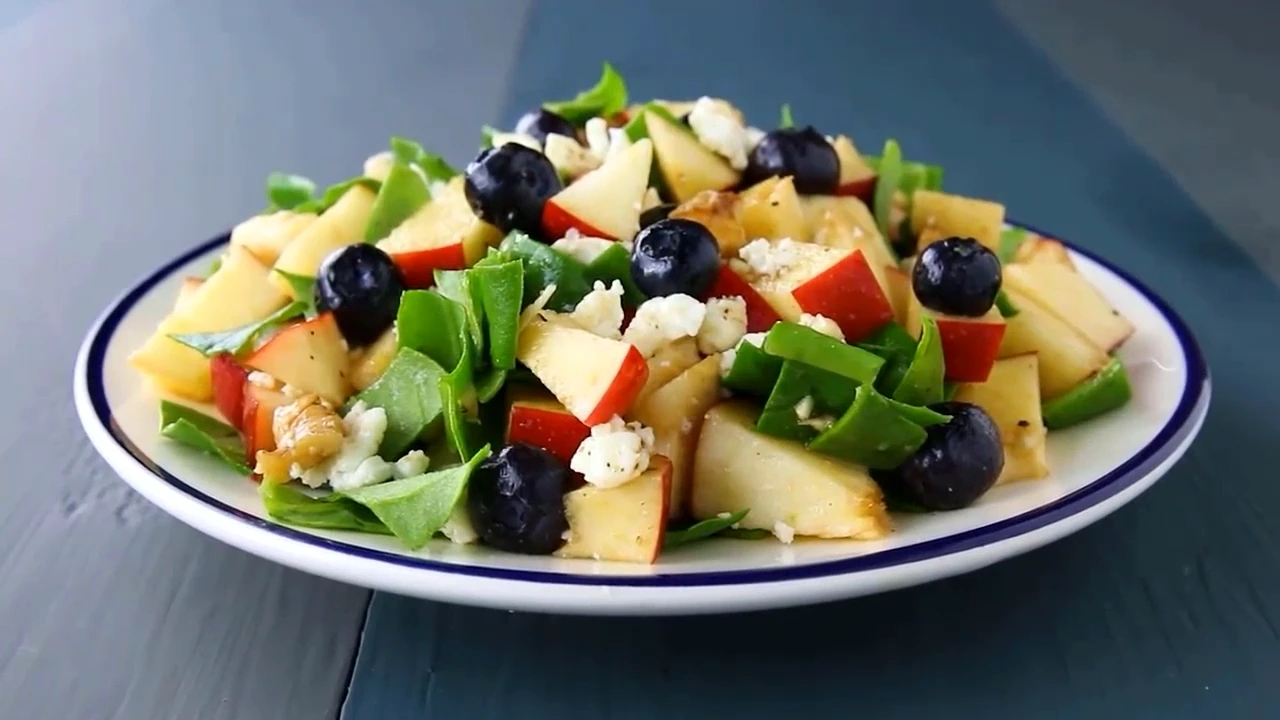 Finished spinach salad with apple and feta served on a plate