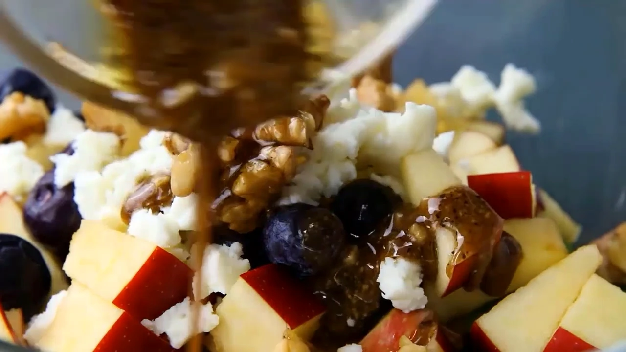 Spinach apple feta salad being tossed together