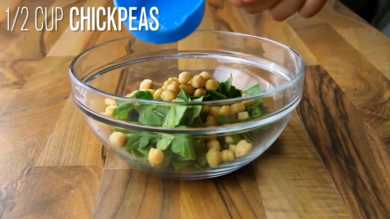 Spinach and chickpeas going into a bowl