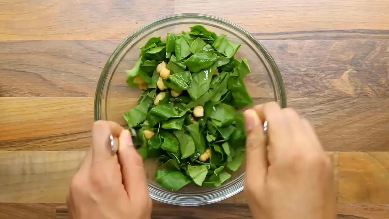 Spinach and chickpeas being tossed together