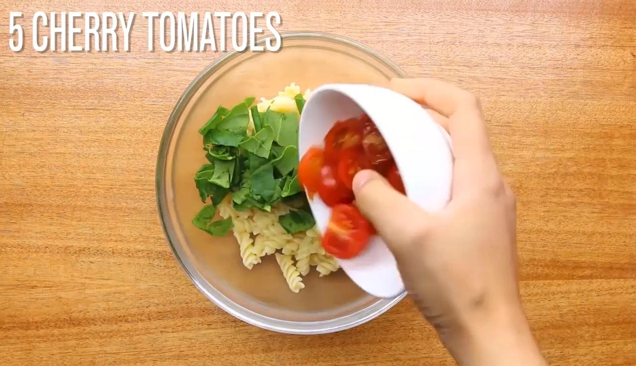 Adding spinach and tomatoes to pasta