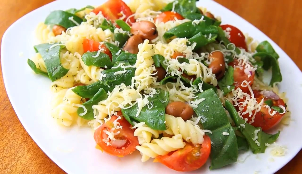 Finished spinach pasta salad with shredded cheese