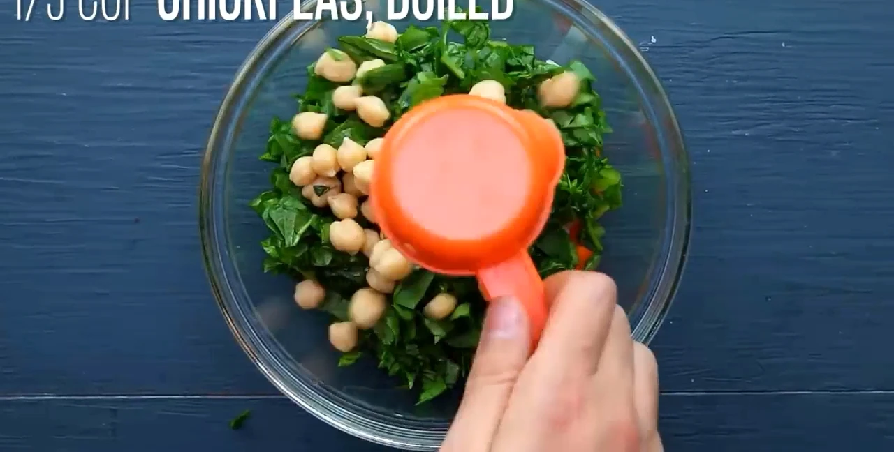 Adding spinach and chickpeas to spinach potato salad.