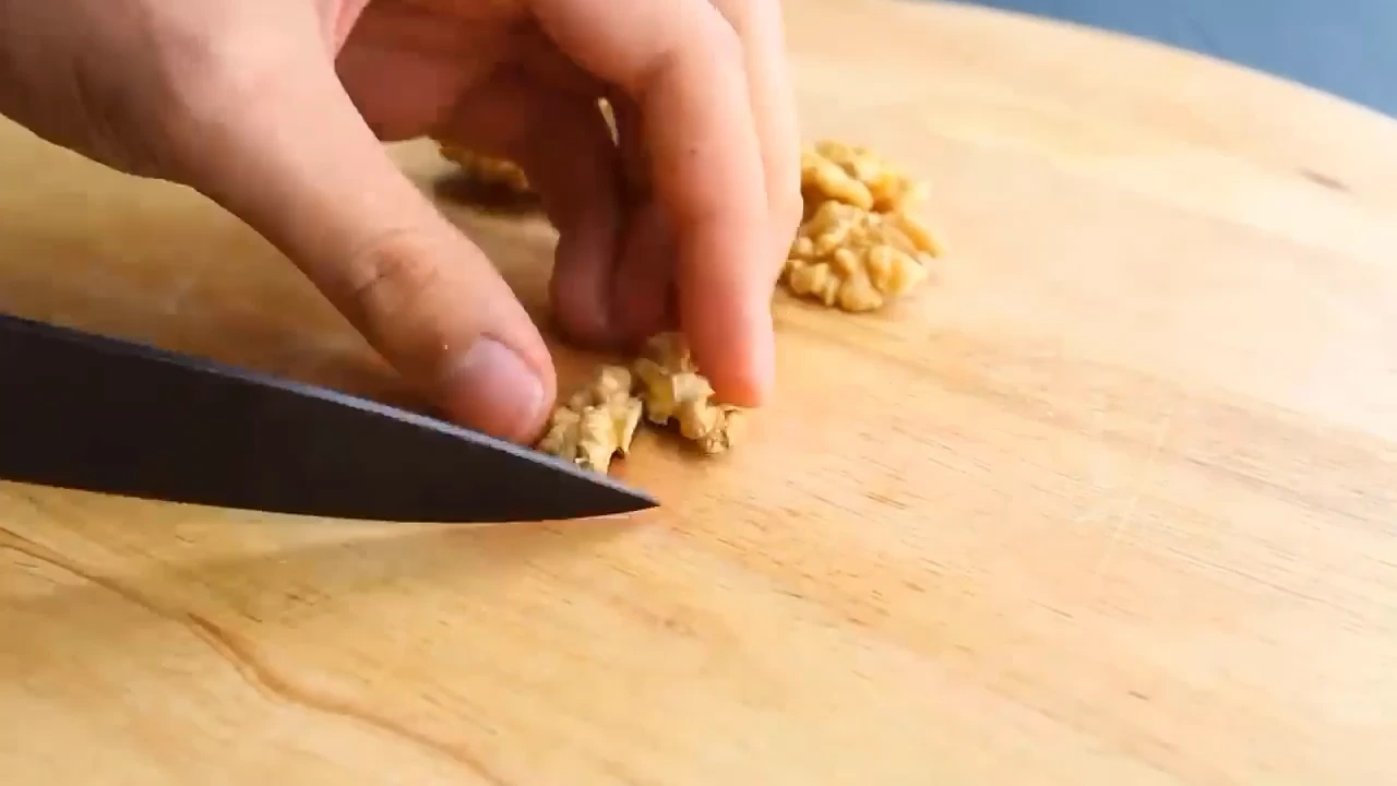 Chopping walnuts on a board.
