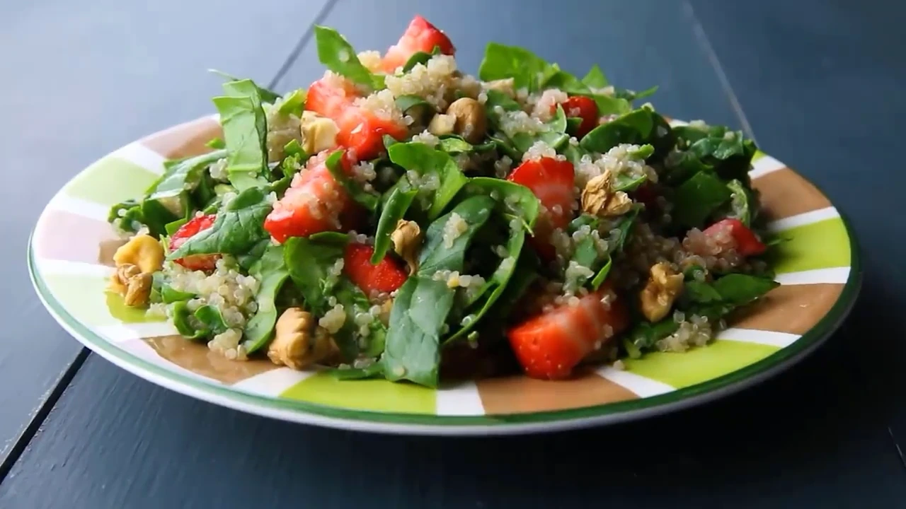 Finished strawberry spinach quinoa salad on a plate.