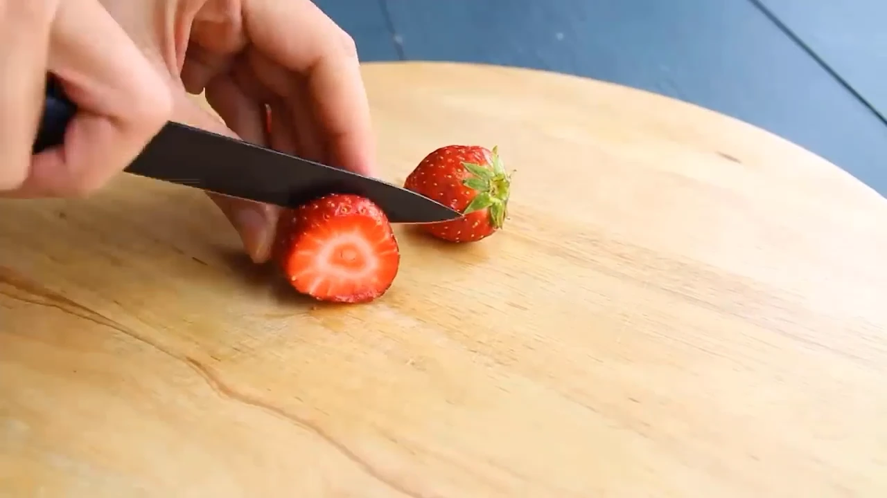 Slicing strawberries on a board.