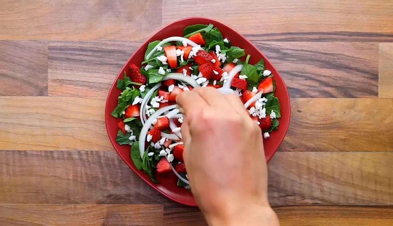 Sprinkling chopped walnuts over the salad