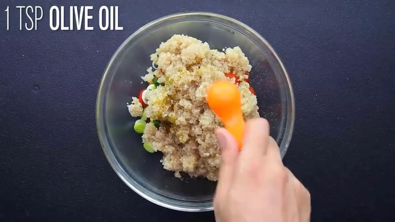 Drizzling olive oil into the quinoa salad bowl.