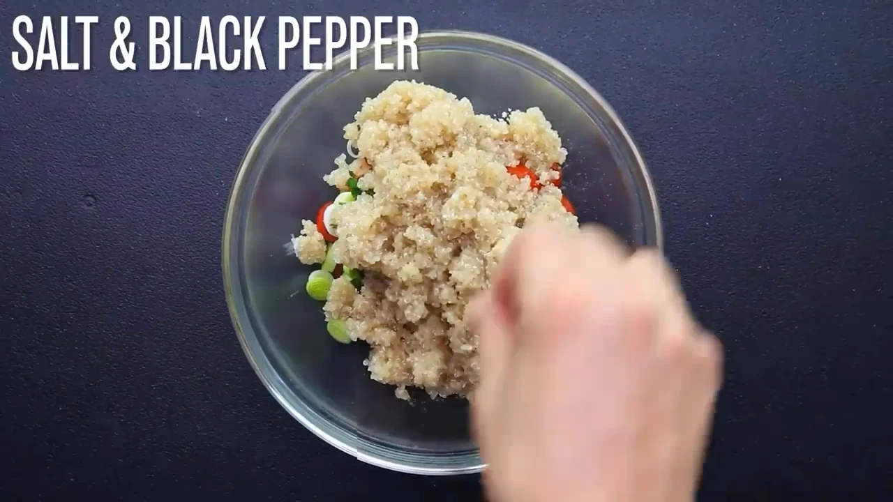 Seasoning the quinoa bowl with salt and black pepper.