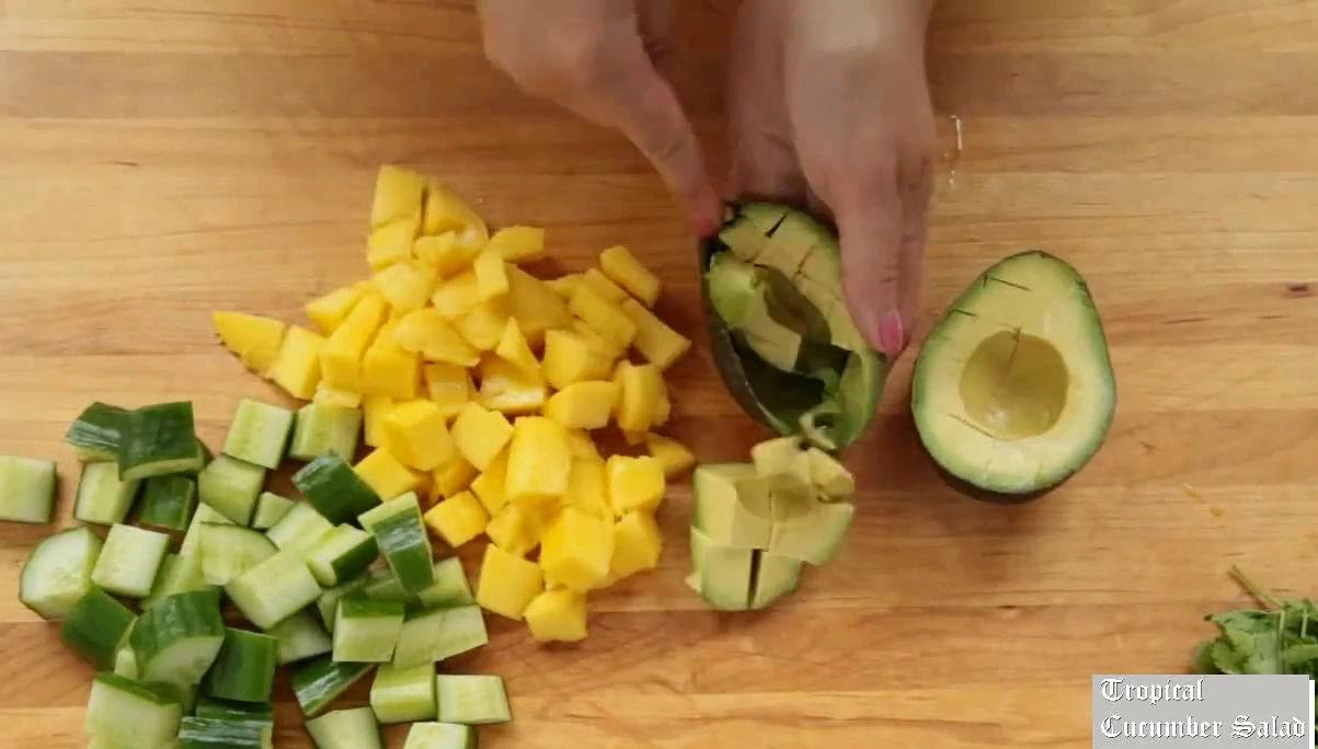 Scooping and dicing avocado for tropical cucumber salad.