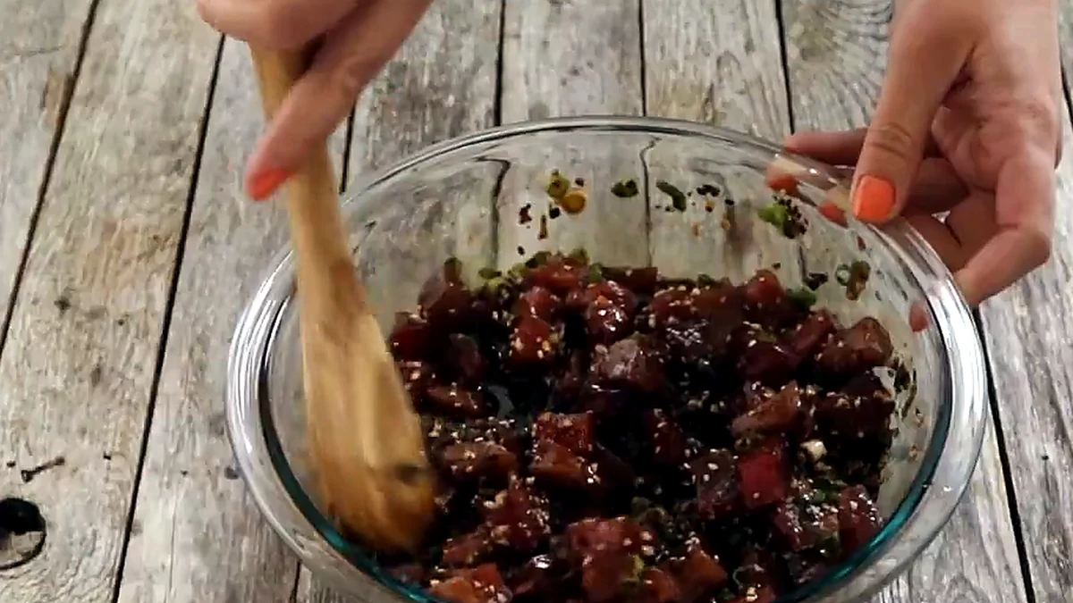 ahi poke mixed with a wooden spoon until coated