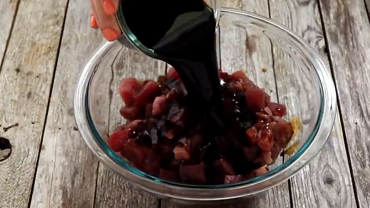 soy sauce poured over cubed tuna in a glass bowl