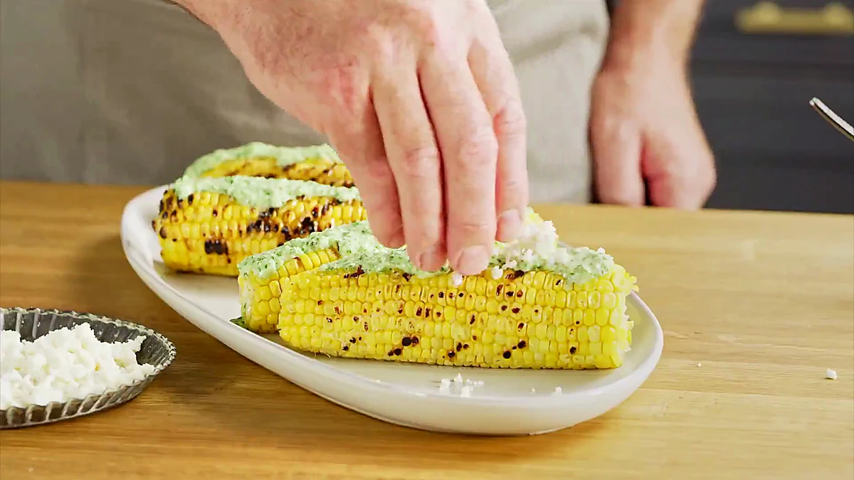 Grilled corn coated with aji verde sauce and queso fresco