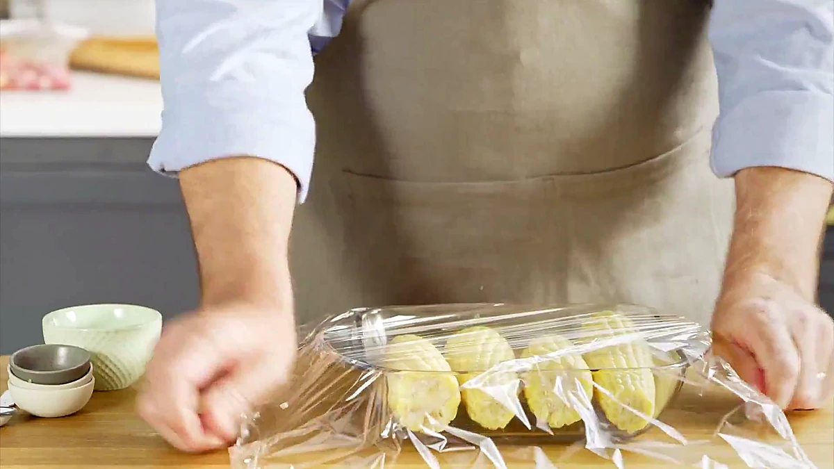 Corn covered with plastic wrap before microwaving