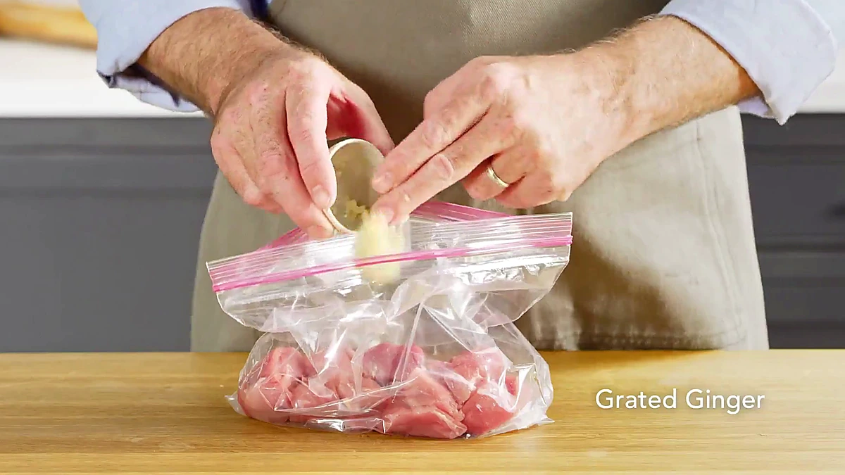 Grated ginger added to pork in a bag