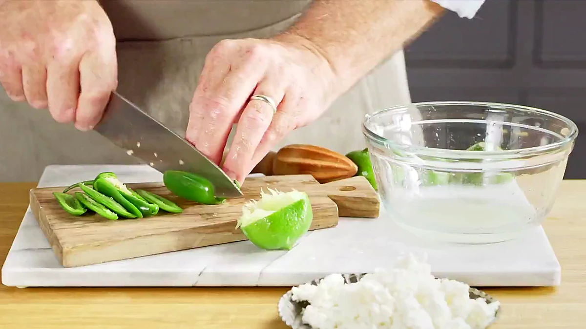 Jalapeno, lime, queso fresco, and sauce ingredients for aji verde pork skewers