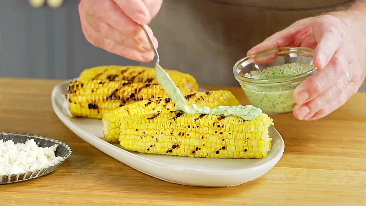 Aji verde sauce spooned over grilled corn