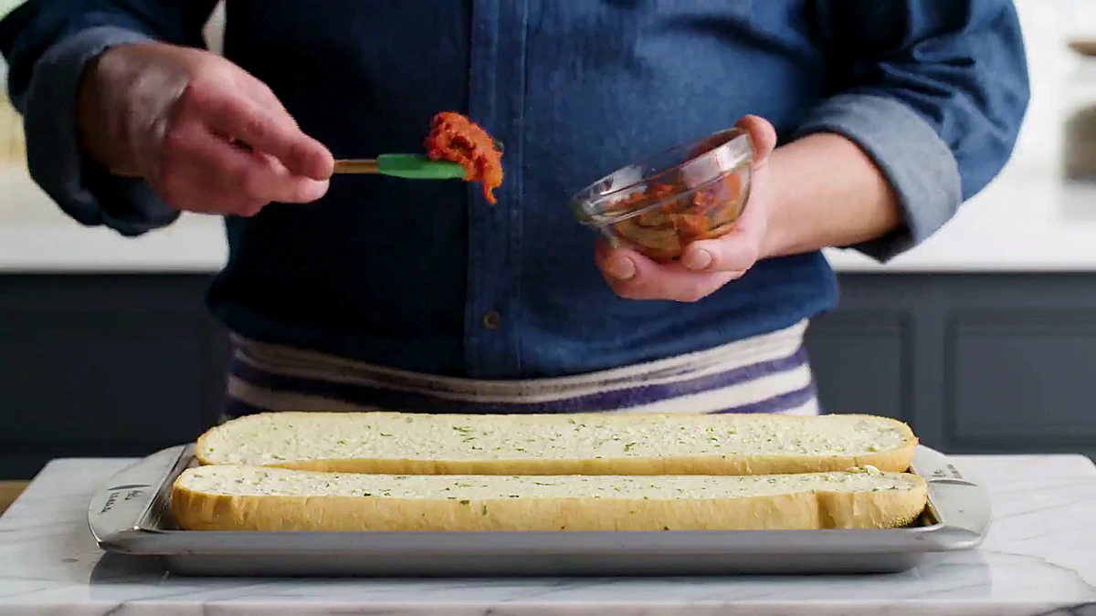 Italian bread split lengthwise on a sheet pan