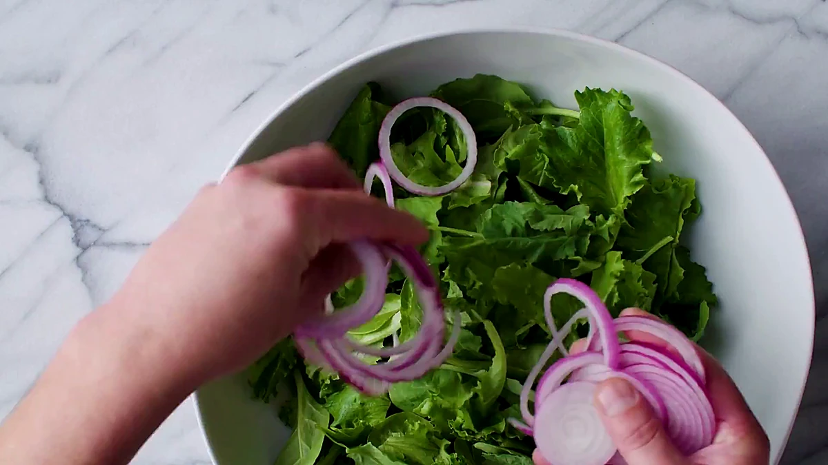 Red onion added to mixed greens