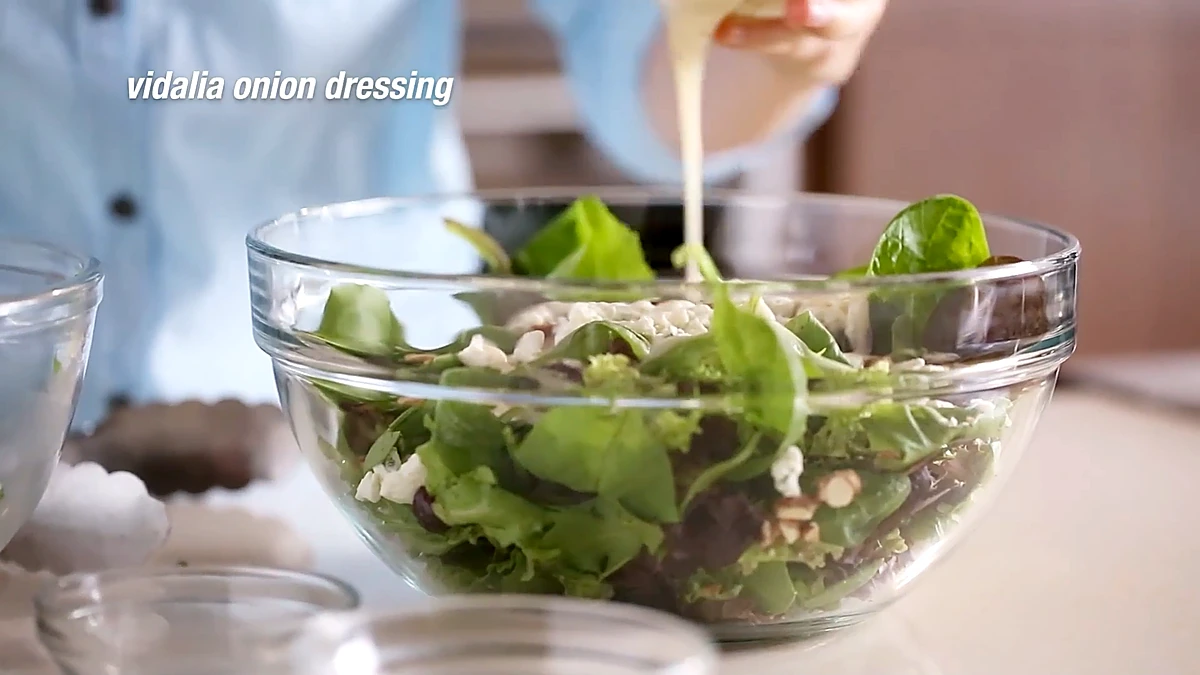 Vidalia onion dressing poured over the salad greens