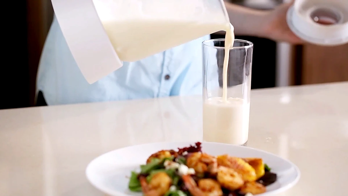 Orange dream shake poured beside the plated shrimp salad