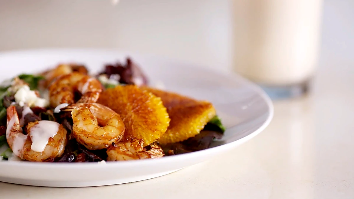 Barbecue shrimp salad served next to an orange dream shake