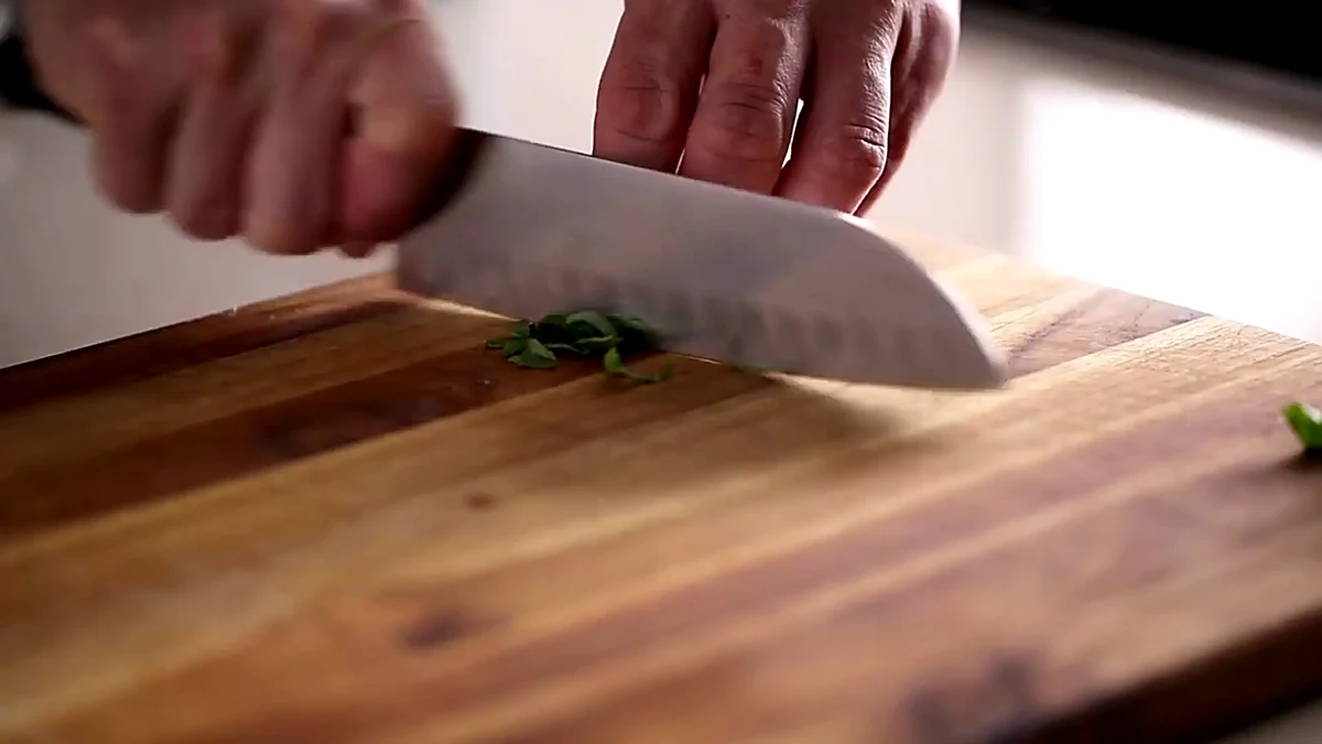 Basil being chopped for cherry mango salmon