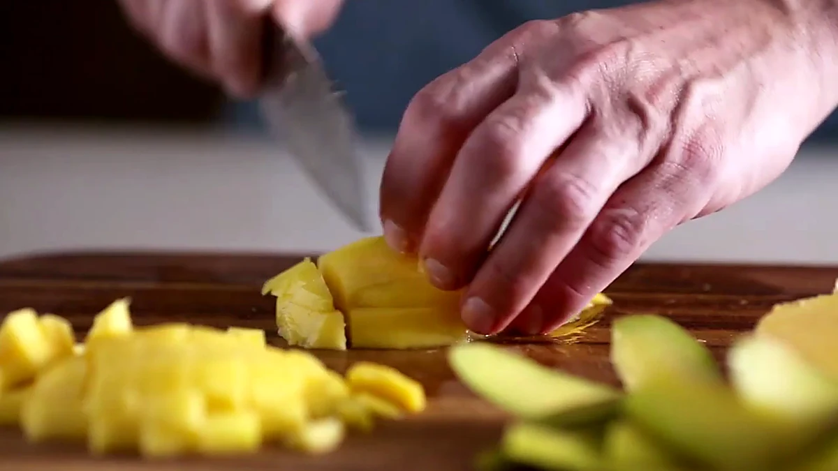 Mango being chopped for salmon topping