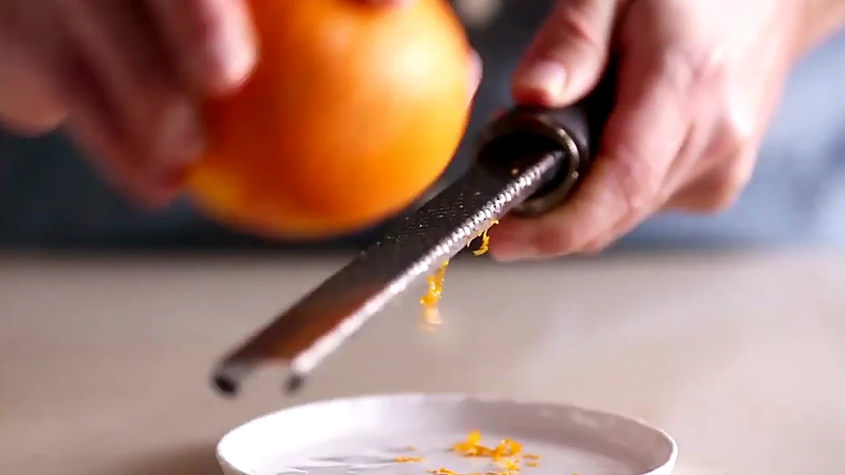 Orange being zested for cherry mango salmon